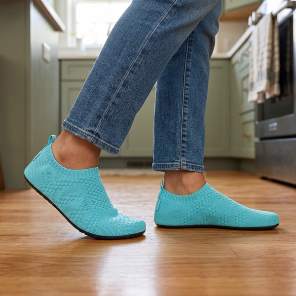 Turquoise Cloud Sock Shoes worn with jeans in a kitchen