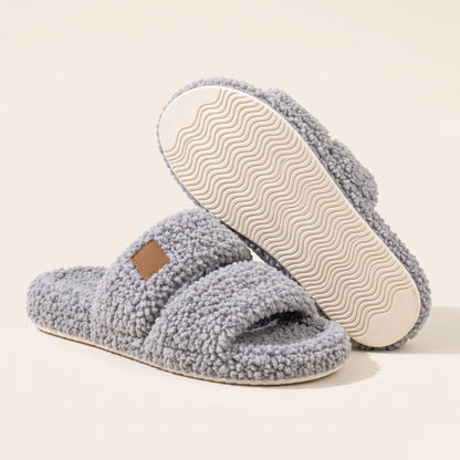 Fuzzy two-strap slides in Gray, one slide flipped to show the wavy cream sole