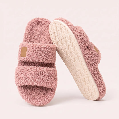 Fuzzy two-strap slides in Blush Pink, one flat and one tilted to show the wavy cream sole