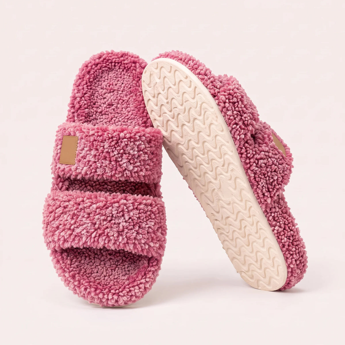 Fuzzy two-strap slides in Raspberry Mix, one flat and one tilted to show the wavy cream sole