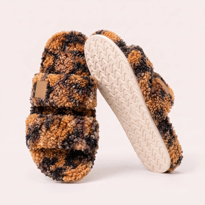 Fuzzy two-strap slides in Tortoise, one flat and one tilted to show the wavy cream sole